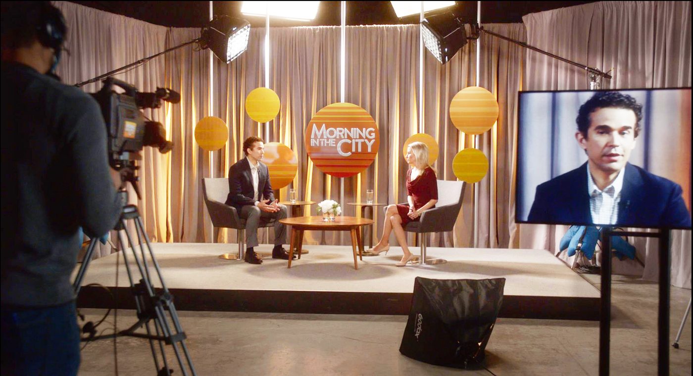 The whole floor at once — camera, lights and monitor, with the graphics holding the background on both sides of the frame.