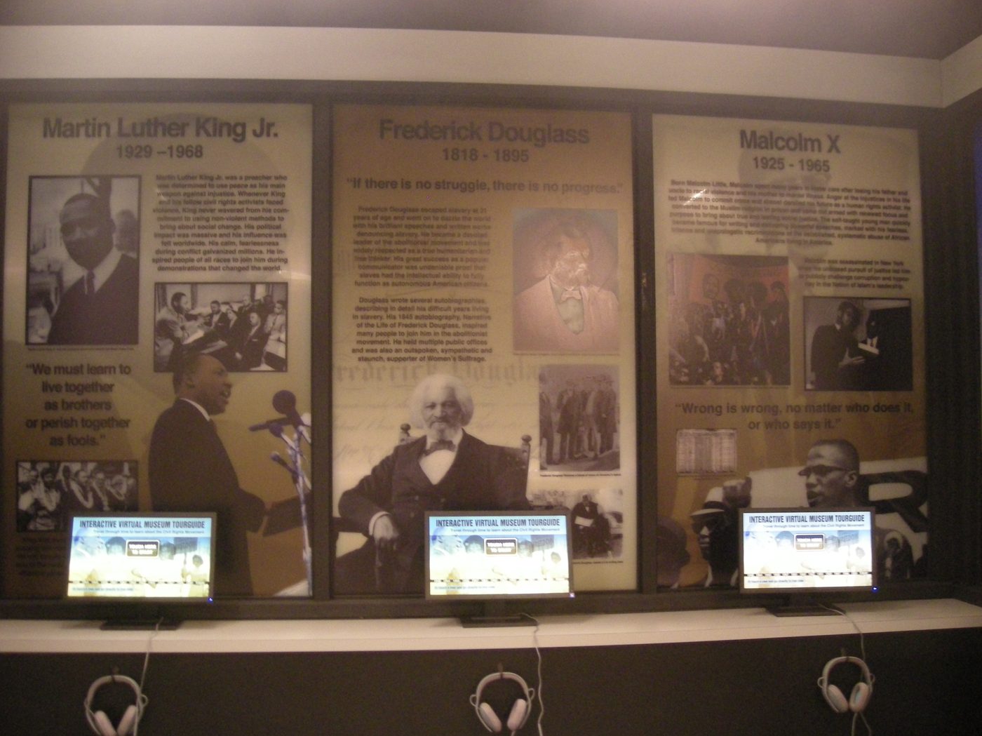 Martin Luther King Jr., Frederick Douglass and Malcolm X, each with dates, quotation and photographs, above a row of listening stations.