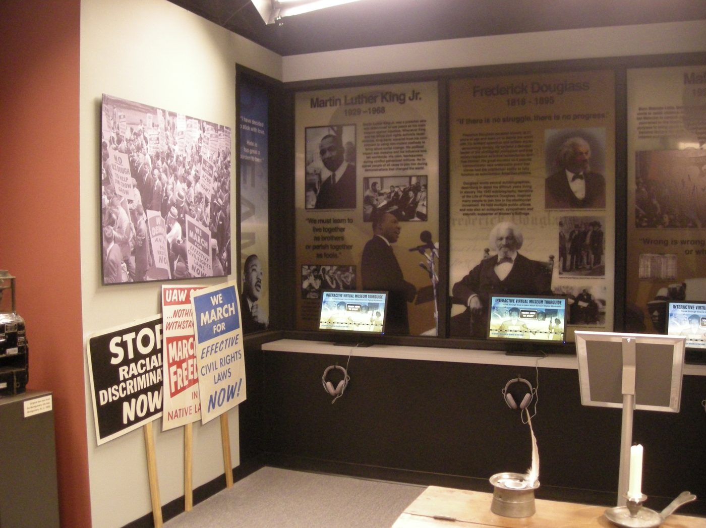 Monitors and headphones set into the panel, so the exhibit reads as interactive before anyone touches it.