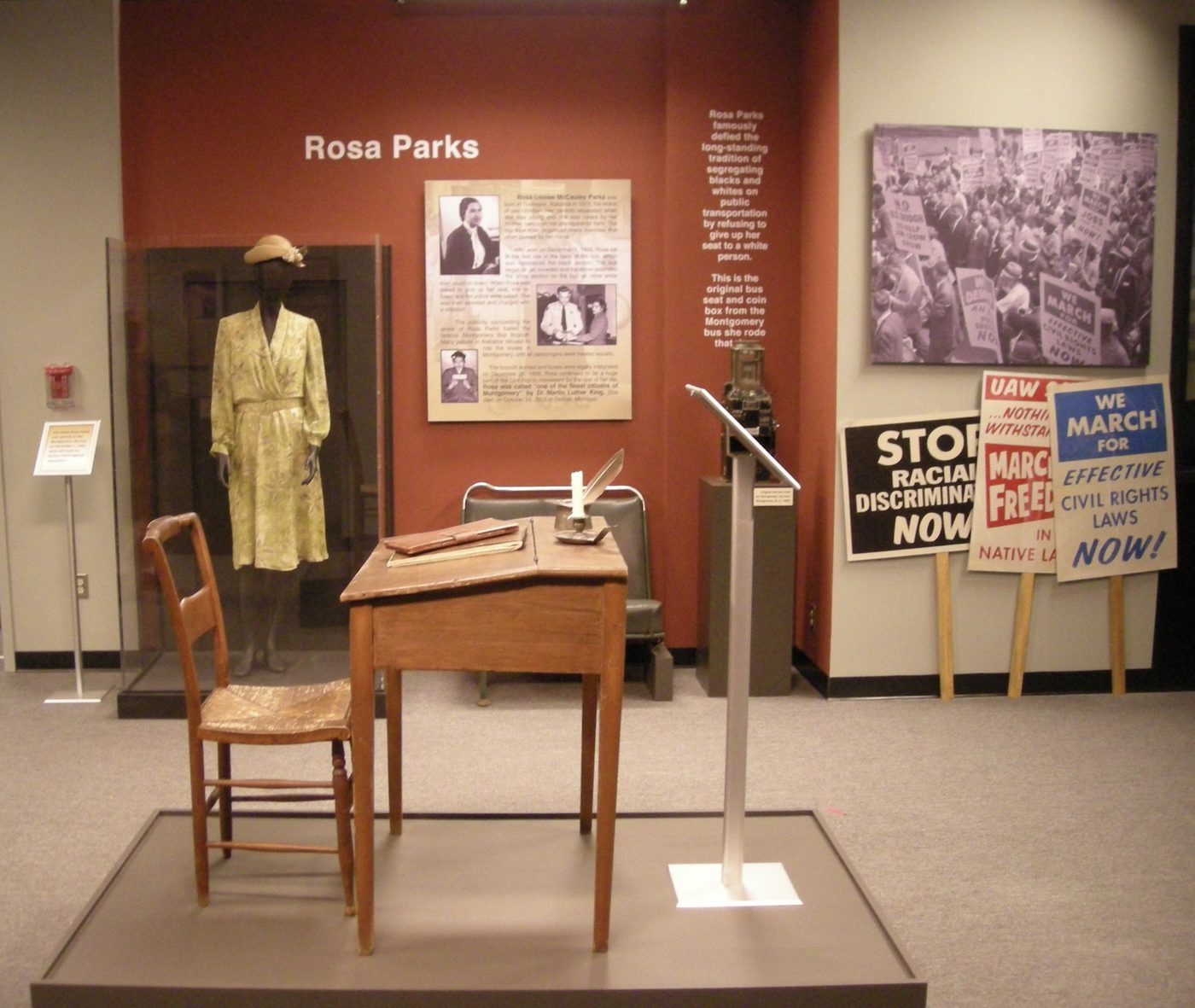 A dress on a mannequin, a bus bench, a doorway and a wall of panels &mdash; one story told with an object, a photograph and a caption.