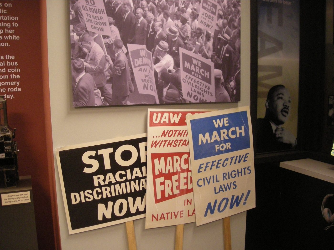 Hand-lettered picket signs on real timber staves, leaning where a museum would lean them.